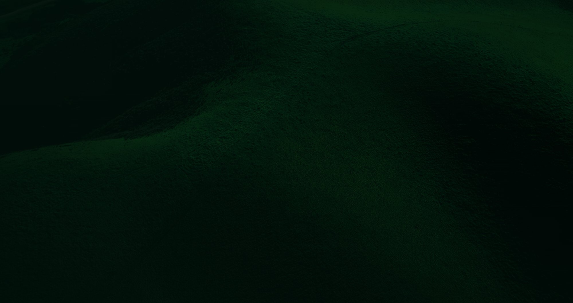 Cresta de colinas verdes en penumbra
